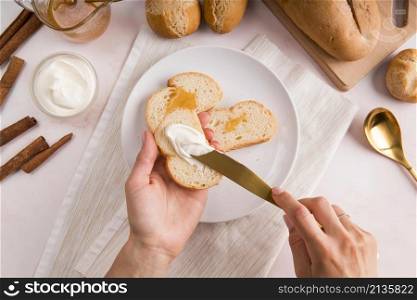 top view woman spreading cream cheese bread