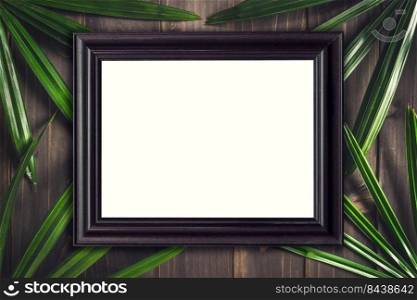 Top view wood frame and green leaf palm tropical on wood background.