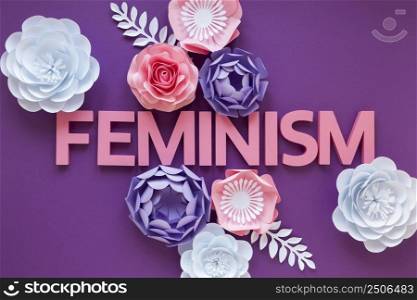 top view word feminism with paper flowers women s day
