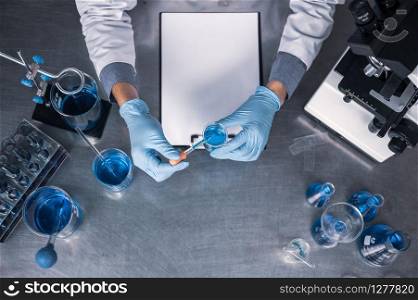 top view workspace in laboratory with microscope, laptop, and laboratory tools