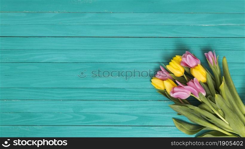 top view yellow pink tulip flowers green wooden desk. Beautiful photo. top view yellow pink tulip flowers green wooden desk
