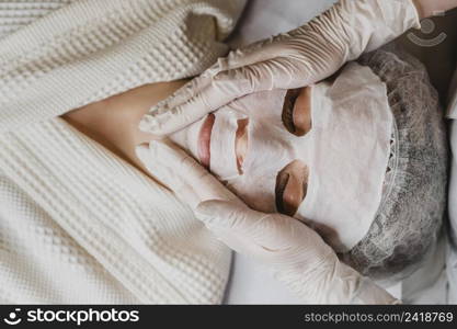 top view young woman getting skin mask treatment