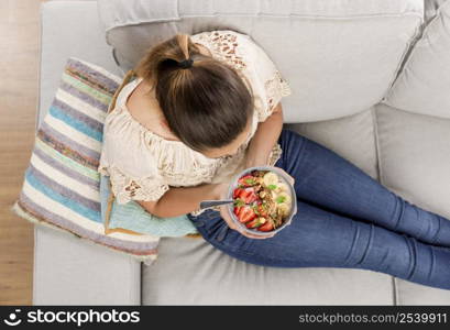 Top viw of a beautiful woman at home eating a healthy bowl