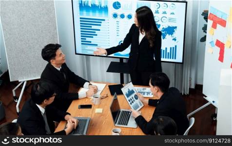 Top widen view of confidence of company presentation on financial analyzed by business intelligence in dashboard report with businesspeople in boardroom meeting to promote harmony in workplace concept. Confidence and young asian businessman give presentation to promote harmony.
