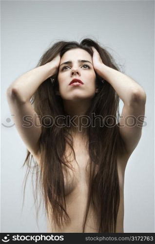 Topless Caucasian woman with hair covering breast.