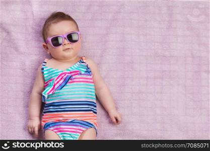 Topview of newborn baby in beachwear on the towel