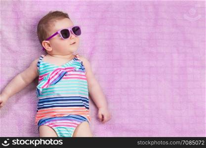Topview of newborn baby in beachwear on the towel