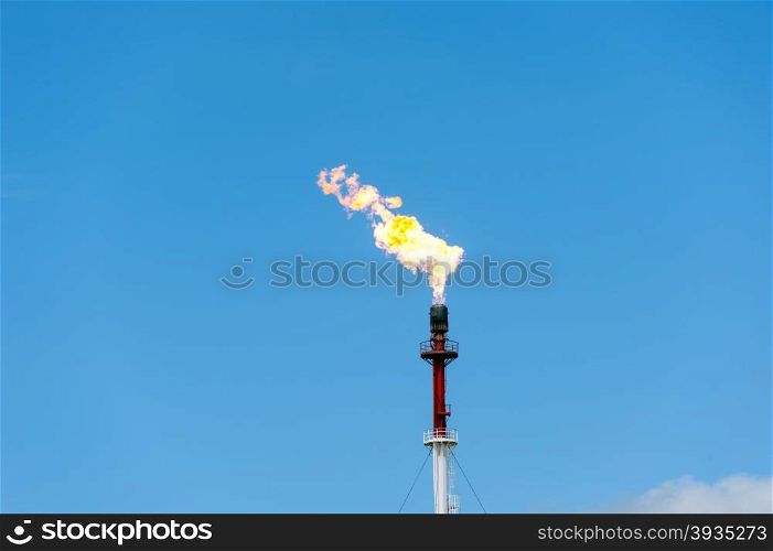 Torch on the blue sky background. Gas flaring.