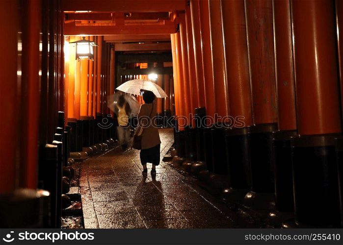 Tori gates in Fushimi Inari Shrine at night with selective focus and blur , Kyoto, Japan