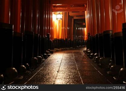 Tori gates in Fushimi Inari Shrine at night with selective focus and blur , Kyoto, Japan