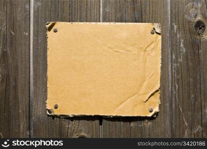 Torn Cardboard On Wooden Wall. Ready For Your Message.