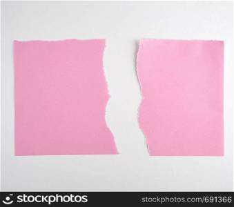 torn in half empty pink sheet of paper on white background, close up
