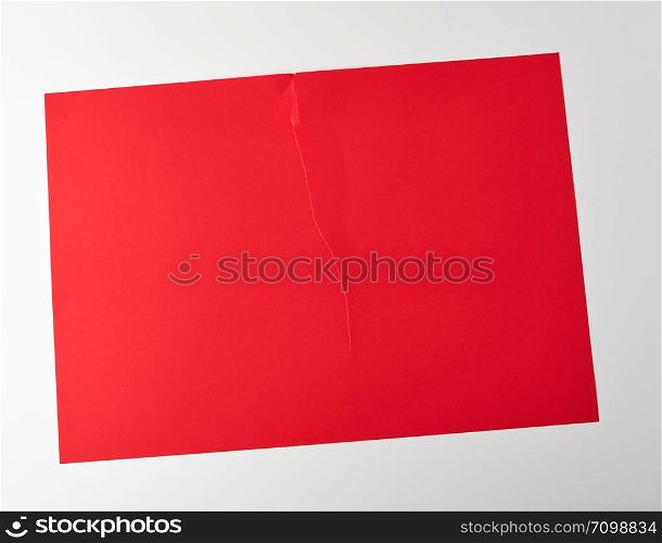 torn in half empty red sheet of paper on white background, close up