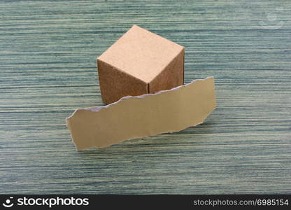 Torn paper and a paper box cube on wooden texture