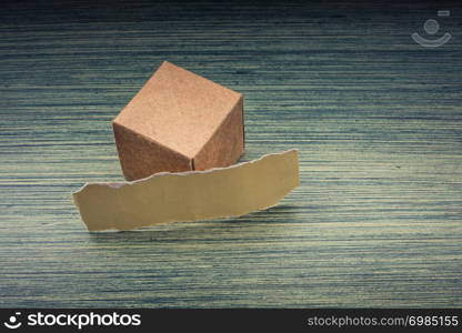 Torn paper and a paper box cube on wooden texture