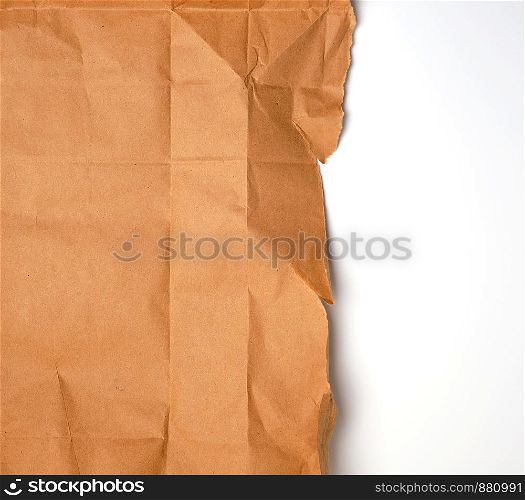torn piece of brown craft paper with torn edges on a white background