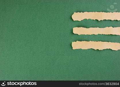 torn strips of newsprint on a green background