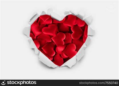 Torn white paper heart over red hearts background with copy space for text, Valentine&rsquo;s day love concept. Torn paper heart