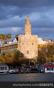 Torre del Oro (Gold Tower) at sunset by the Guadalquivir river, medieval landmark from early 13th century in Seville, Spain, Andalusia region.