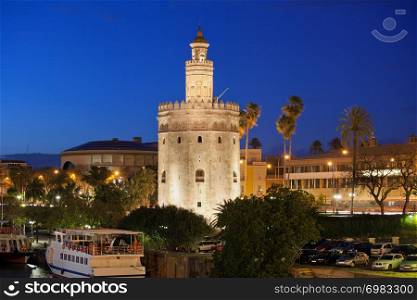 Torre del Oro (Gold Tower) illuminated at night, medieval landmark from early 13th century in Seville, Spain, Andalusia region.