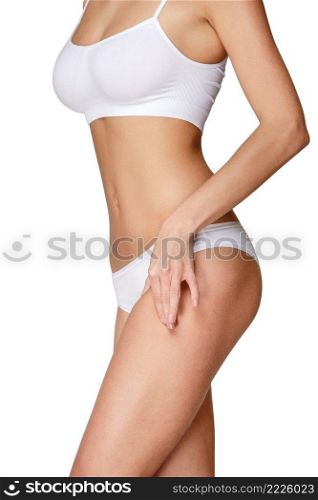 Torso of luxurious woman in white bikini studio shot. Torso of woman in white bikini sunbathing