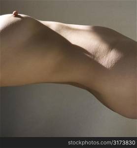 Torso of nude woman arching back.