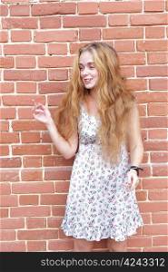 torso portrait of beautiful blonde girl in vintage dress standing near brick wall and enjoing
