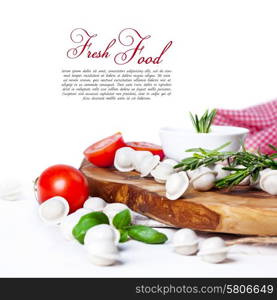 Tortellini and vegetables on white wooden background