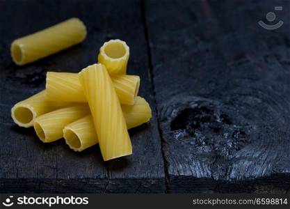 Tortiglioni noodle on dark rustic wood.. Tortiglioni noodle on dark rustic wood