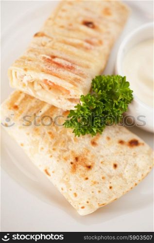 tortilla with chicken breast tomato and cheese served with sour cream. tortilla