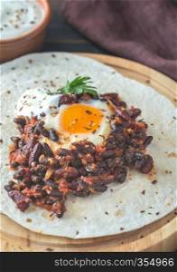 Tortilla with chipotle bean chili and baked egg