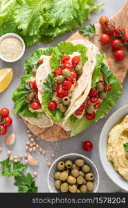 Tortilla wraps with chickpea hummus, fresh tomatoes and olives, vegan food