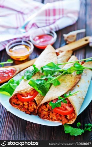 tortilla wraps with meat and vegetables on plate