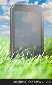 touch screen phone is standing in grass outdoors