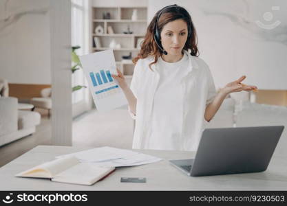 Tough woman has corporate internet session on laptop. Pretty european girl demonstrates charts and works on startup project. Businesswoman is brainstorming online. Remote business on quarantine.. Tough woman has internet session on laptop. Girl demonstrates charts and works on startup project.