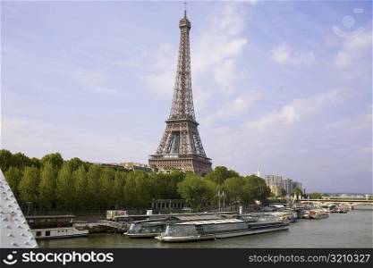 Tourboats moored at the riverbank with a tower in the background, Eiffel Tower, Seine River, Paris, France