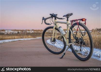 touring bicycle at dusk in late fall or winter scenery - one of numeous bike trail in Fort Collins, northern Colorado, recreation and commuting concept
