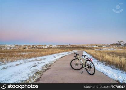 touring bicycle at dusk in late fall or winter scenery - one of numerous bike trail in Fort Collins, northern Colorado, recreation and commuting concept