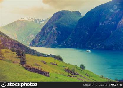 Tourism and travel. Mountains landscape and cruise liner ship sailing on the fjord, Norway Scandinavia.. Cruise ship ferryboat on norwegian fjord