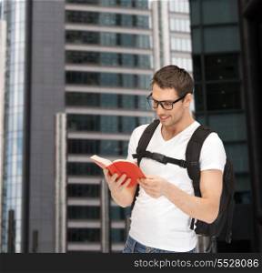 tourism, education and vacation concept - travelling student in eyeglasses with backpack and book