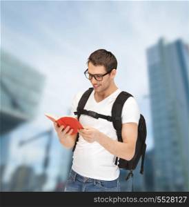 tourism, education and vacation concept - travelling student in eyeglasses with backpack and book