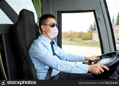 tourism, health and people concept - male driver wearing face protective medical mask for protection from virus disease driving travel bus. male driver in mask driving intercity bus
