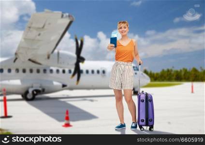 tourism, summer holidays and vacation concept - happy teenage girl in sunglasses with travel bag and air ticket over plane on airfield background. teenage girl with travel bag and airplane ticket