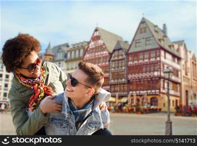 tourism, travel and people concept - happy teenage couple in shades having fun over frankfurt am main city street background. happy couple having fun in frankfurt
