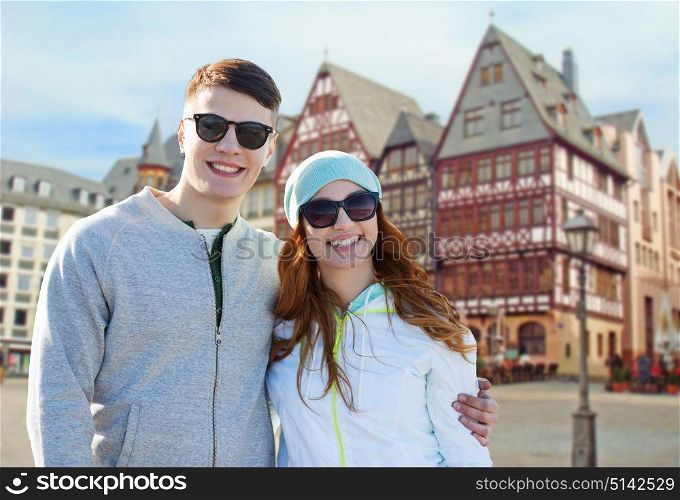 tourism, travel and people concept - happy teenage couple over frankfurt am main city street background. happy teenage couple over frankfurt am main city