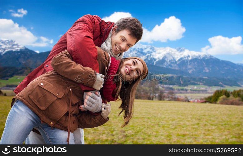 tourism, travel and people concept - happy young couple having fun over alps mountains background. happy young couple having fun over alps mountains
