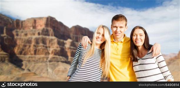 tourism, travel and summer holidays concept - group of happy friends over grand canyon national park background. group of happy friends. group of happy friends