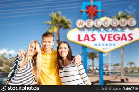 tourism, travel and summer holidays concept - group of happy friends over welcome to fabulous las vegas sign background. happy friends over welcome to las vegas sign. happy friends over welcome to las vegas sign