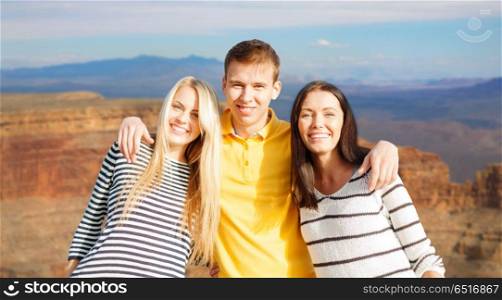 tourism, travel and summer holidays concept - group of happy friends over grand canyon national park background. group of happy friends. group of happy friends