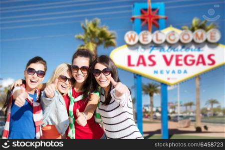 tourism, travel and summer vacation concept - group of happy smiling women or friends showing thumbs up over welcome to fabulous las vegas sign background. group of happy women or friends at las vegas
